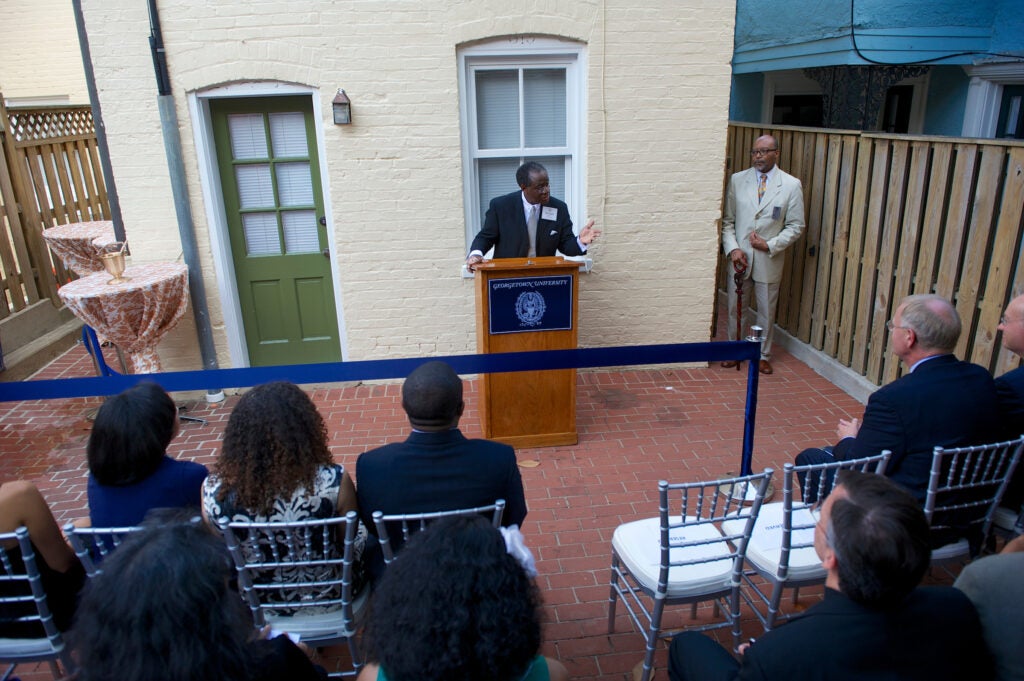 black house reception and dedication - speaker at the podium at the back of the black house